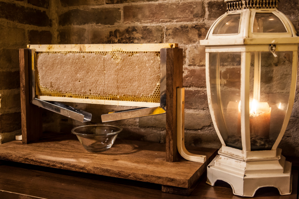 favo di miele con telaio nel rustico con lampada a candela accesa della Bottega Montecchia a Teramo in Abruzzo